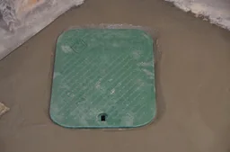 Finished backwater valve access cover set into new concrete