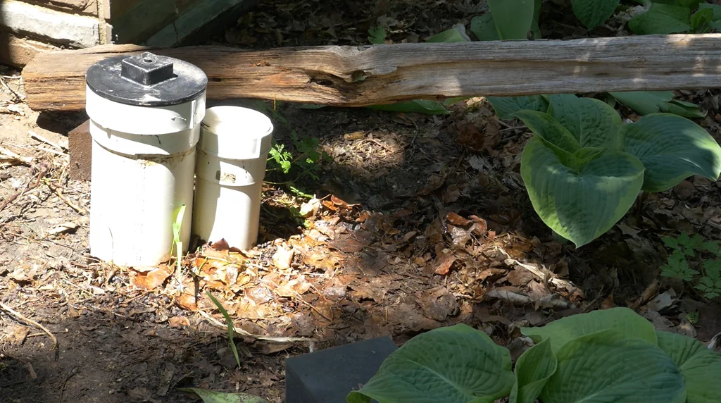 Exterior sewer access and cleanout pipes installed beside a home